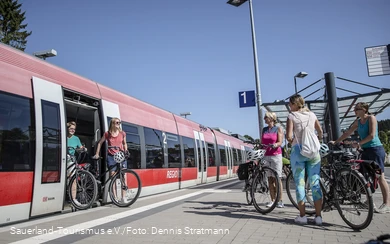 Twee vrouwen stappen met hun fiets uit de trein in Winterberg.